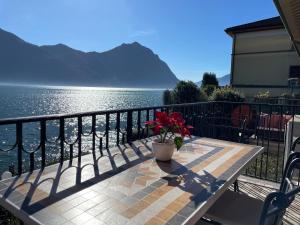 un tavolo con una pianta su un balcone affacciato sull'acqua di Blue Lake a Lovere