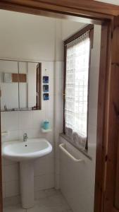 uma casa de banho com um lavatório e uma janela em 2 bedrooms property at Villasimius 1 km away from the beach em Villasimius