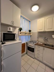 een keuken met witte kasten en een fornuis met oven bij OhMyHome - View Apartment Grzybowska in Warschau
