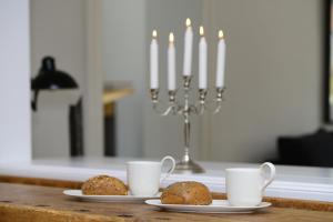 zwei Teller mit Muffins auf einem Tisch mit zwei Kerzen in der Unterkunft Gesine in Flensburg