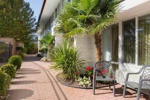 a patio with two benches and plants next to a building at Days Inn by Wyndham Victoria Airport Sidney in Sidney