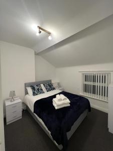 ein Schlafzimmer mit einem Bett mit zwei Handtüchern darauf in der Unterkunft Apartments 7 Greenfield Road in Liverpool