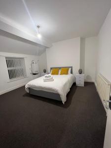 a white bedroom with a large white bed with orange pillows at Apartments 7 Greenfield Road in Liverpool