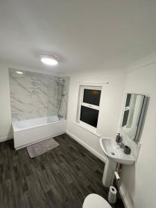 a bathroom with a toilet and a sink and a tub at Apartments 7 Greenfield Road in Liverpool