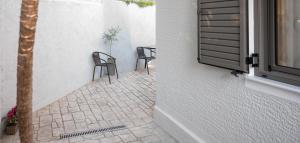 two chairs sitting on a patio next to a window at Kefaloviso Luxury Apartment 2 in Nafpaktos