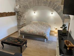 - une chambre avec un lit et un mur en pierre dans l'établissement Superbe logement "Loulaloue" !, à Ornans
