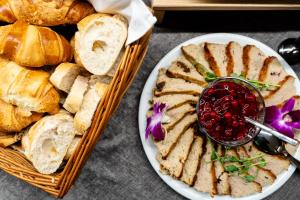 a plate of bread and a basket of croissants and cranberry sauce at Mazurkowa - z widokiem na Karkonosze i Śnieżkę, darmowy parking, obok restauracja Mazurkowa Chata in Jelenia Góra
