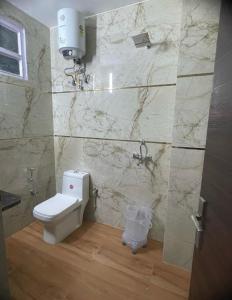a bathroom with a white toilet and a marble wall at Hotel Airport inn plaza near delhi airport Aerocity in New Delhi