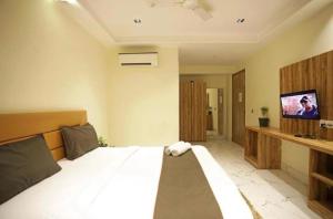 a bedroom with a bed and a flat screen tv at Hotel Airport inn plaza near delhi airport Aerocity in New Delhi