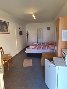 Kleines Zimmer mit einem Bett und einer Küche in der Unterkunft Fenyő Panzió in Mezőkövesd