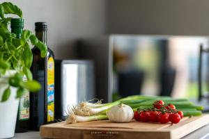 una tabla de cortar con verduras y una botella de vino en Seebrise, en Gelting
