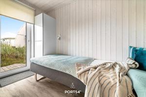 a bedroom with a bed and a large window at Ferienhaus Küstenschatz Marina Wendtorf in Wendtorf