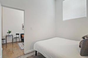 a white bedroom with a bed and a table at 1BR Adorable Apt with In-unit Laundry - Lake 206 in Chicago
