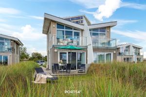 a large house with a table and chairs in a field at Ferienhaus Möwennest Marina Wendtorf in Wendtorf