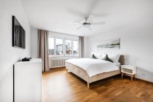 Habitación blanca con cama y TV en Familienwohnung !Gratis Parken, Free Parking!, en Kreuzlingen