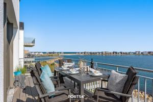 un tavolo e sedie su un balcone affacciato sull'acqua di Seewind a Olpenitz Altre 17 foto