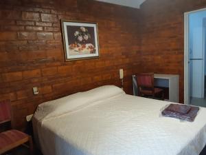 1 dormitorio con cama y pared de ladrillo en ENCANTOS DE MENDOZA Apartments en Mendoza