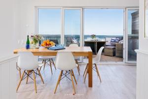 a dining room with a table and chairs with a view at An der Ostsee 17 in Olpenitz