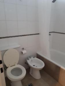 a white bathroom with a toilet and a sink at ENCANTOS DE MENDOZA Apartments in Mendoza