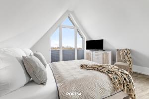 a white bedroom with a bed and a window at Küste 3 in Büsum