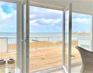 a room with a balcony with a view of the ocean at Oceanhouse in Olpenitz
