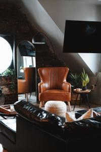 a living room with a leather chair and a mirror at Trumbull 300 in Detroit