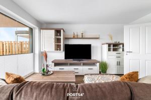 a living room with a couch and a flat screen tv at Küste 2 in Büsum