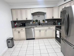 a kitchen with white cabinets and stainless steel appliances at Urban Oasis 3 Kings bed 3Mins from EWR-NYC Downtow in Newark