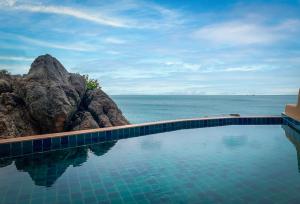 a swimming pool with a view of the ocean at Baan Hin Sai Resort & Spa in Chaweng Noi Beach