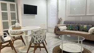 uma sala de estar com um sofá, uma mesa e cadeiras em Center City, PUERTA DEL SOL em Madri