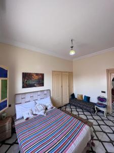 ein Schlafzimmer mit einem großen Bett und einer gestreiften Decke in der Unterkunft الشويطر in Chouiter
