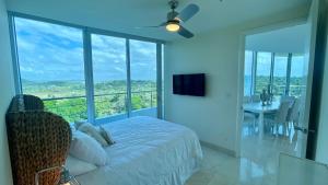 1 dormitorio con 1 cama y balcón con mesa en 10G Perfect 2 Bedroom with Ocean and Jungle Views, en ArraijÃ¡n