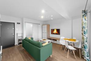 een woonkamer met een groene bank en een tafel bij Ametist Apartment with parking in Floreşti