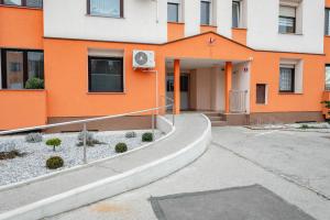un edificio naranja y blanco con entrada en Apartma Golob en Maribor