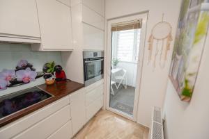 a kitchen with white cabinets and a counter top at Apartma Golob in Maribor