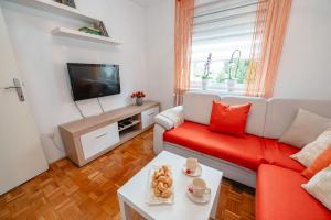 a living room with a red couch and a tv at Apartma Golob in Maribor
