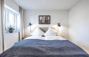 1 dormitorio con 1 cama grande con almohadas blancas en Schlei-Koje 1, en Schleswig