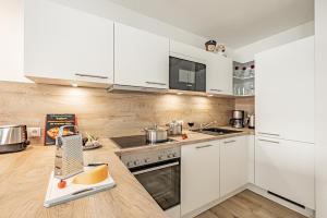 a kitchen with white cabinets and white appliances at Schlei-Koje 2 in Schleswig