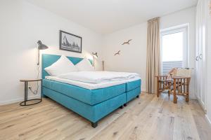 1 dormitorio con 1 cama azul en una habitación en Schlei-Koje 3, en Schleswig