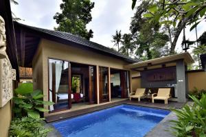 a house with a swimming pool in the backyard at Gino Feruci Villa Ubud by KAGUM Hotels in Ubud