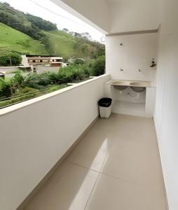 - un balcon blanc avec vue sur une colline dans l'établissement NossoApê Recanto: Casa de 3 quartos em Lima Duarte, à Lima Duarte