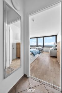 einen großen Spiegel im Wohnzimmer mit Sofa in der Unterkunft Waterfront 7601 Marina Wendtorf in Wendtorf
