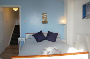 a bedroom with a bed with blue walls and blue pillows at Chwerthin Y Mor Beach House in Tywyn