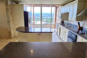 a kitchen with a counter top and a large window at Dream Penthouse Escazú in San Rafael