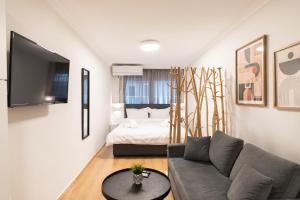a living room with a couch and a bed at Central Nest in Thessaloniki