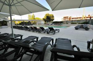 a row of chairs and an umbrella next to a pool at Space atlantic 1 in Portimão