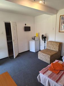 Una sala de estar con un sofá y un refrigerador. en Fenyő Panzió, en Mezőkövesd