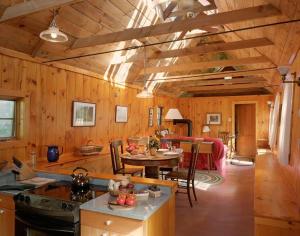 cocina y sala de estar con paredes y techos de madera. en The Sugar House en East Dummerston