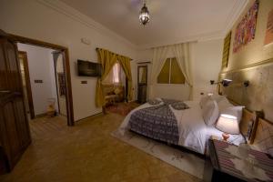 ein Schlafzimmer mit einem großen Bett in einem Zimmer in der Unterkunft Tin Joseph in Ouarzazate