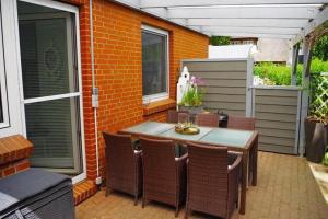 an outdoor patio with a table and chairs at Semi-detached house Nordseebrise Niebüll - DNS09100i-L in Niebüll